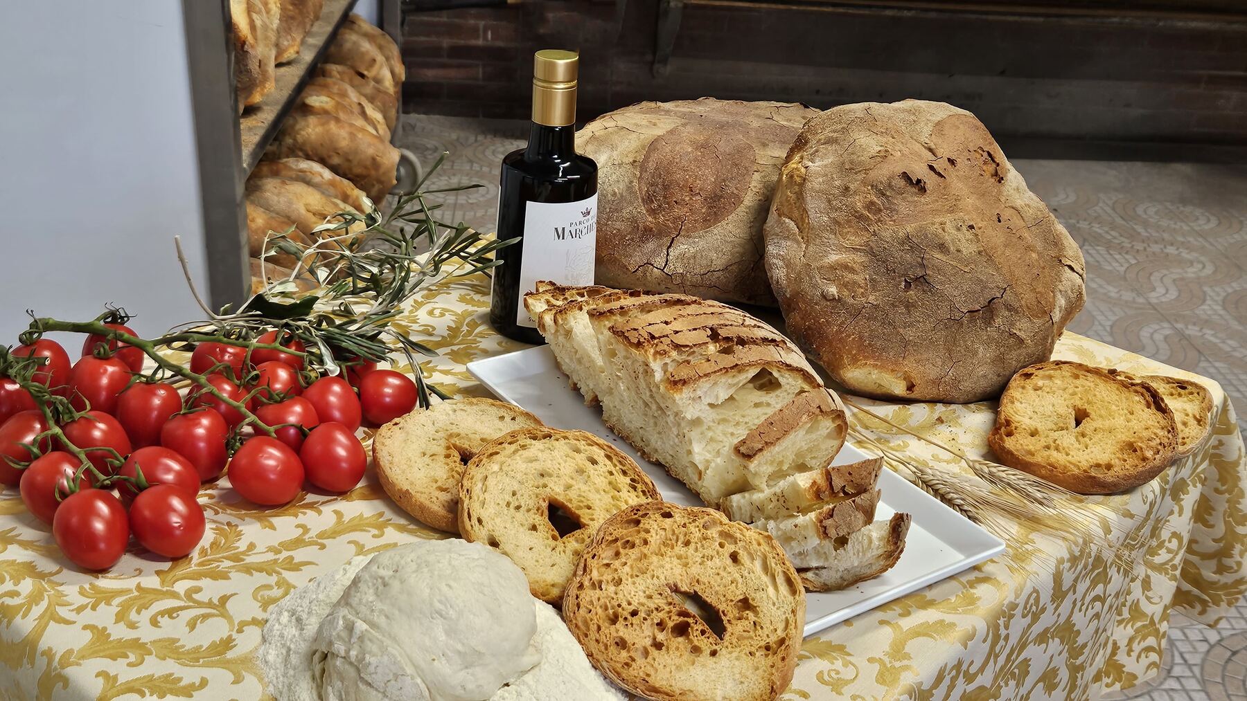Table de spécialités italiennes : pain, huile d'olive extra vierge et tomates cerises